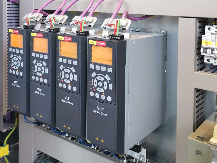 Multiple complicated electrical devices with glowing yellow screens daisy-chained together labelled VLT HVAC Drive frequency converter
