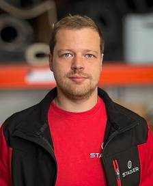 Man in front of a warehouse wall