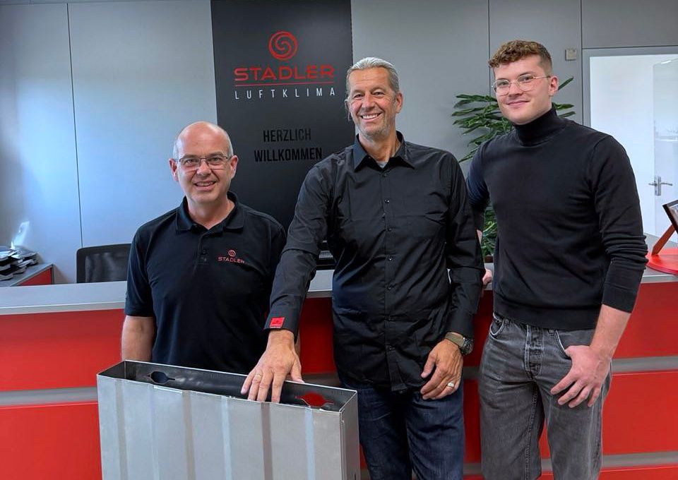 Peter Huber, Rüdiger Stadler und Michael Vetter stehen vor einem ESSONIC Wandmodul vor dem Logo der Stadler Luftklima.