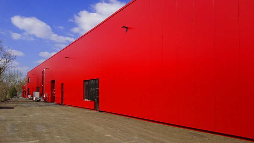 Sehr rote Gebäudeseite unter blauem Himmel