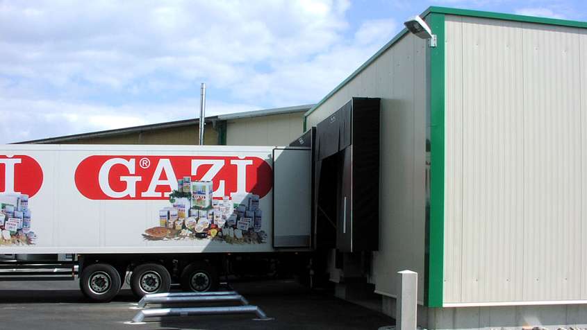 Truck with a red label reading “Grazi” being unloaded at a docking station