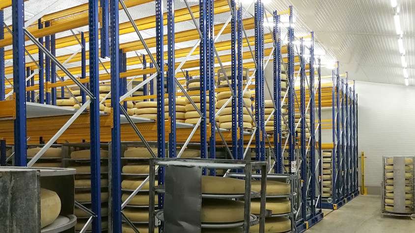 Emmentaler cheese being stored in blue shelves