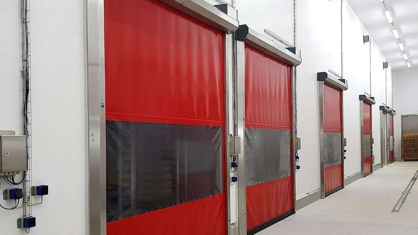 Red rollable plastic gates along a hallway