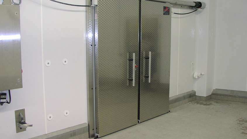 Thick metal sliding door in a white wall
