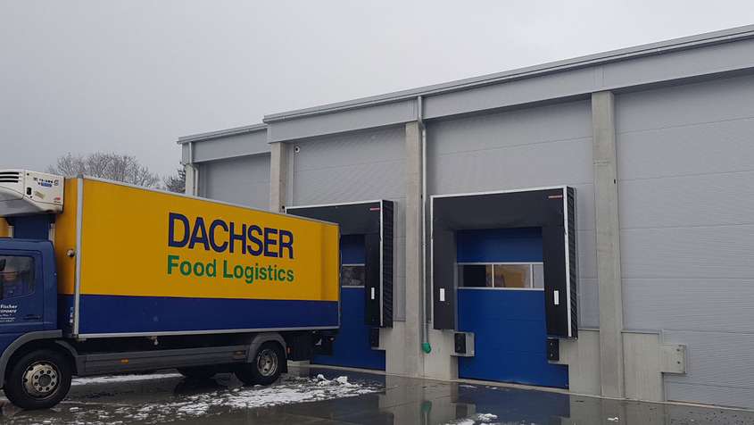 Verladebrücke an einem Lager mit einem blau-gelben LKW mit der Aufschrift „Dachser Food Logistics“