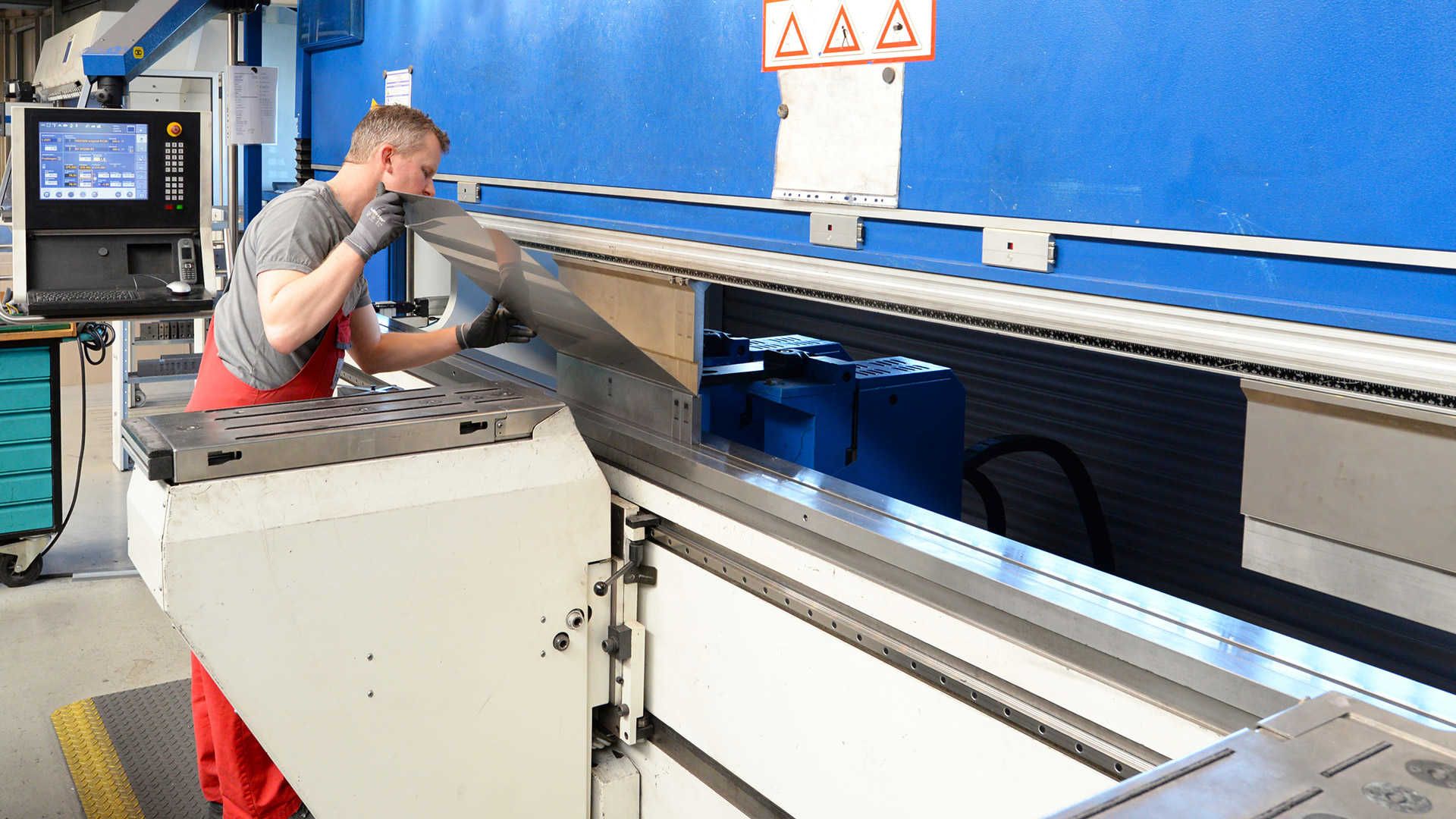 A man while trimming a piece of sheet metal