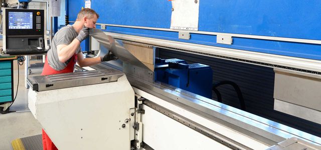 A man working on a piece of sheet metal