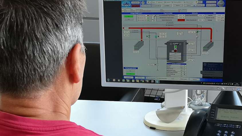 A man at a computer during the remote maintenance of a ripening room