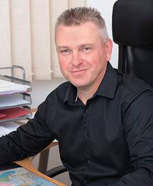 Portrait of a man in a black shirt at a desk