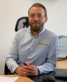 Portrait of a man in a blue shirt at a desk