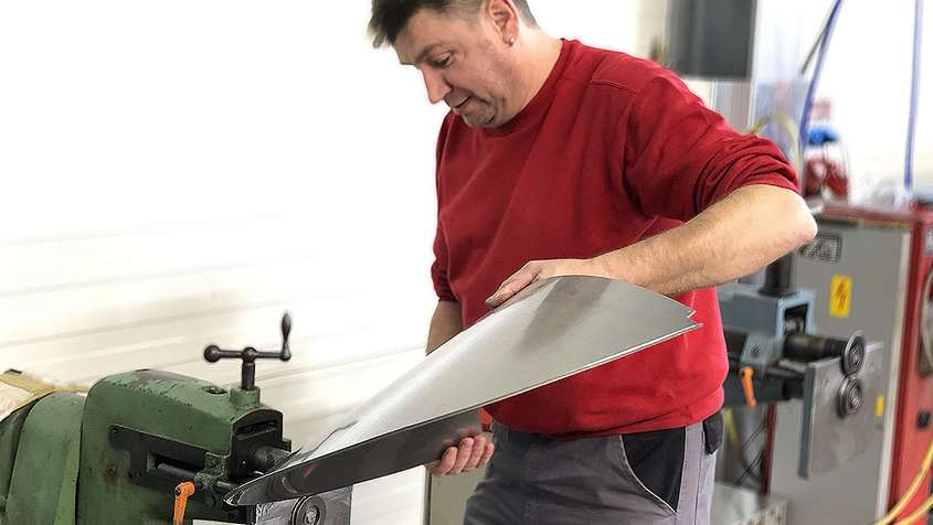 A man beading a piece of sheet metal