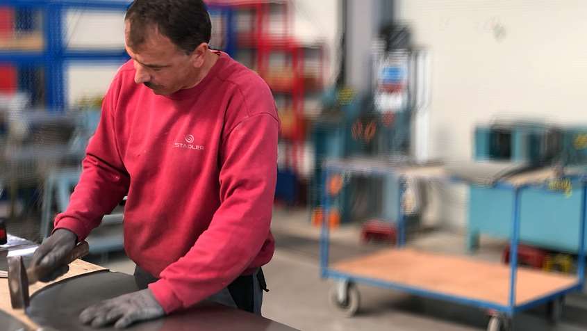 A man flanging a piece of sheet metal