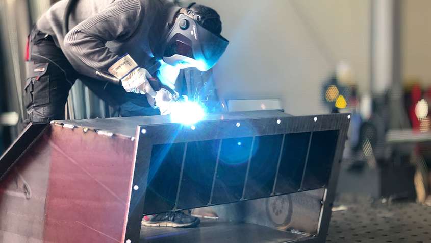 A man welding a metal workpiece