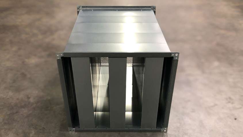 A square pipe filled with three frames that hold perforated metal sheets within