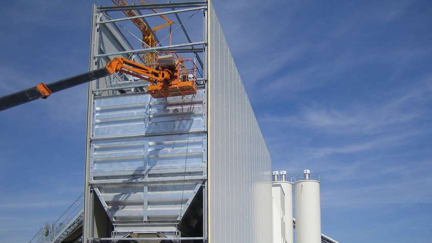 Orange crane in front of an unfinished building component