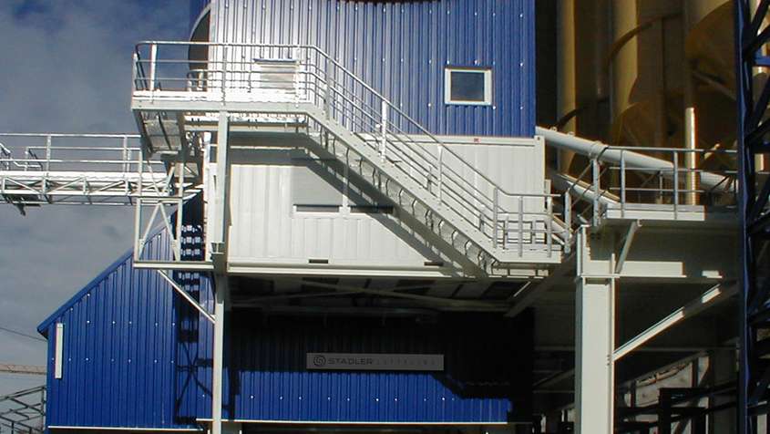 White staircase on the side of a blue metal building