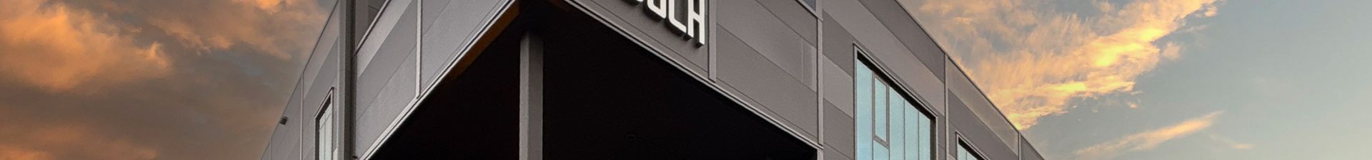 Perspektivansicht eines modernen Industriegebäudes vor vor einem Sonnenuntergang.