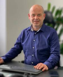 Portrait of a stout man sitting at a desk