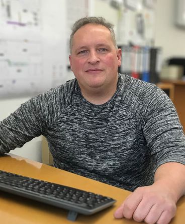 Portrait of a stout man sitting at a desk