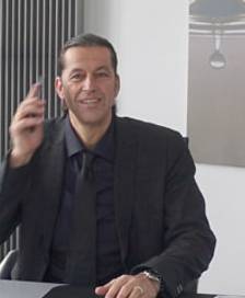 Rüdiger Stadler sitting at his desk while talking on the phone