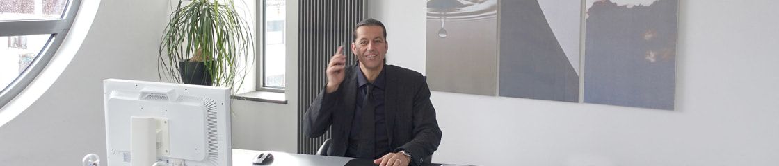 Rüdiger Stadler sitting at his desk while talking on the phone