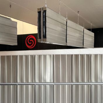 Demoinstallation von ESSONIC-Geräten in einer Halle. Manche hängen an einer Wand, Andere hängen von der Decke.